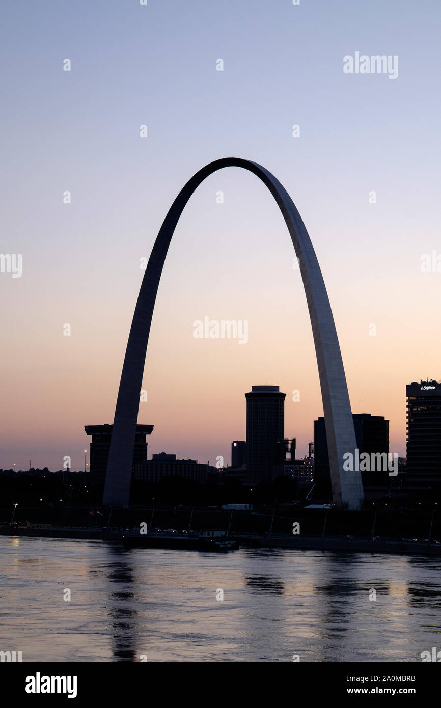 With the Gateway Arch standing out against a colorful sunset, the St. Louis skyline is seen over the Mississippi River Stock Photo
