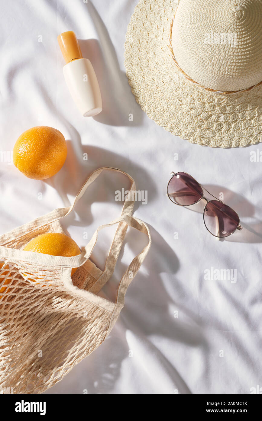 Flat lay Picnic, with glasses, an orange bag, sun cream and a straw hat with space. Summer mood Stock Photo