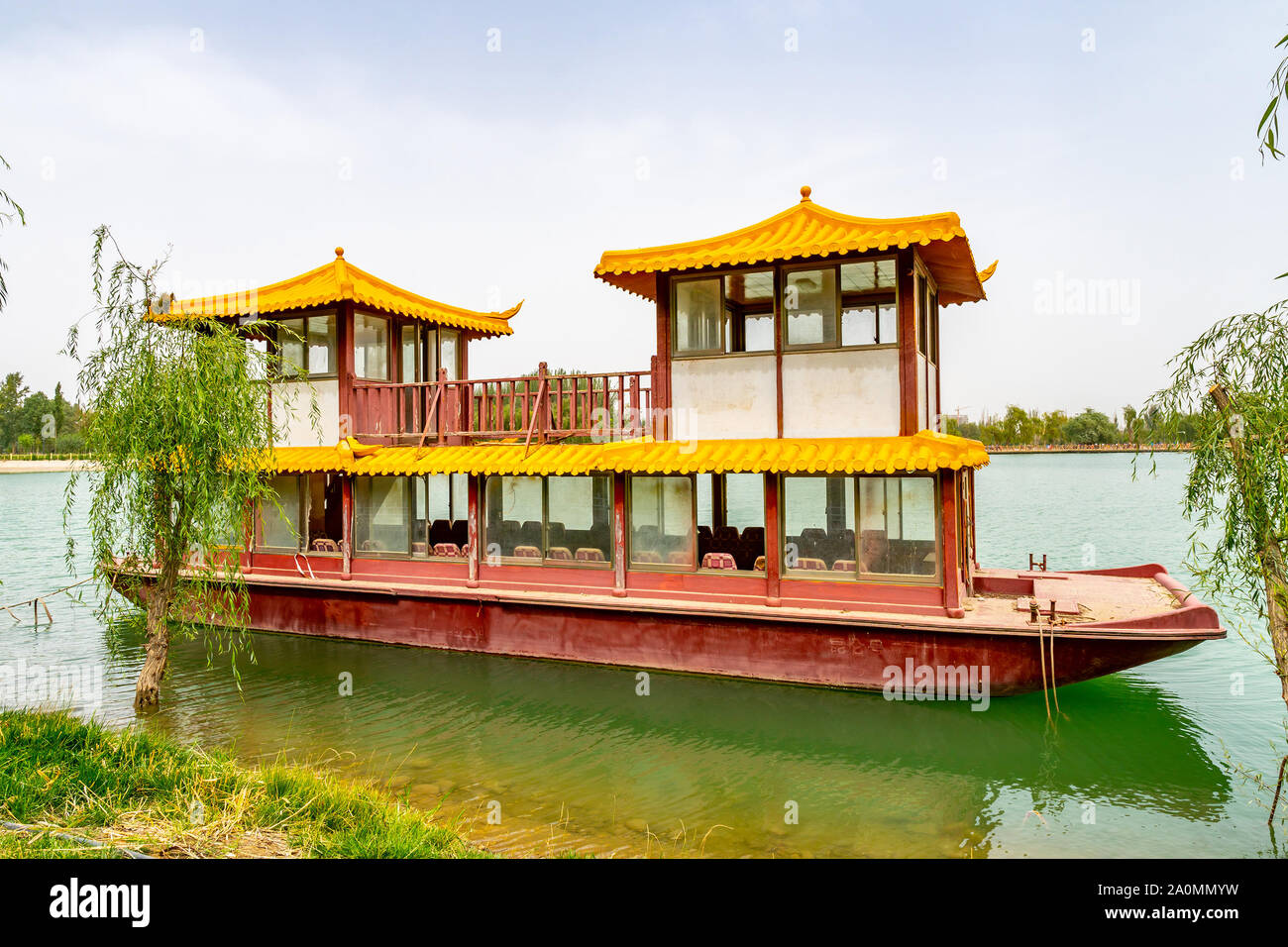 Hotan Picturesque Kunlun Lake Park View of an Anchored Chinese Ship at the Shore on a Cloudy Blue Sky Day Stock Photo