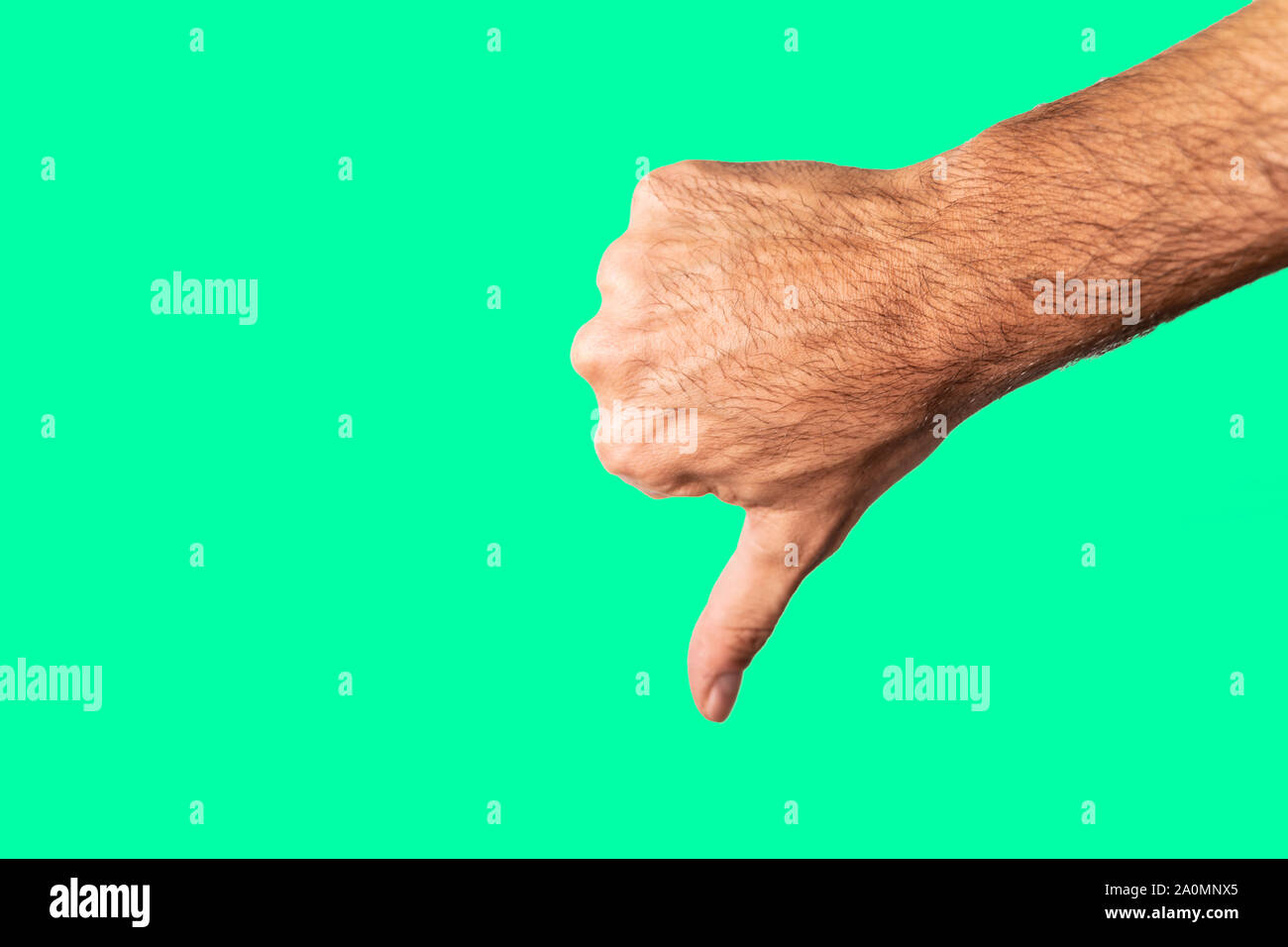Thumb down hand sign isolated on a green background Stock Photo