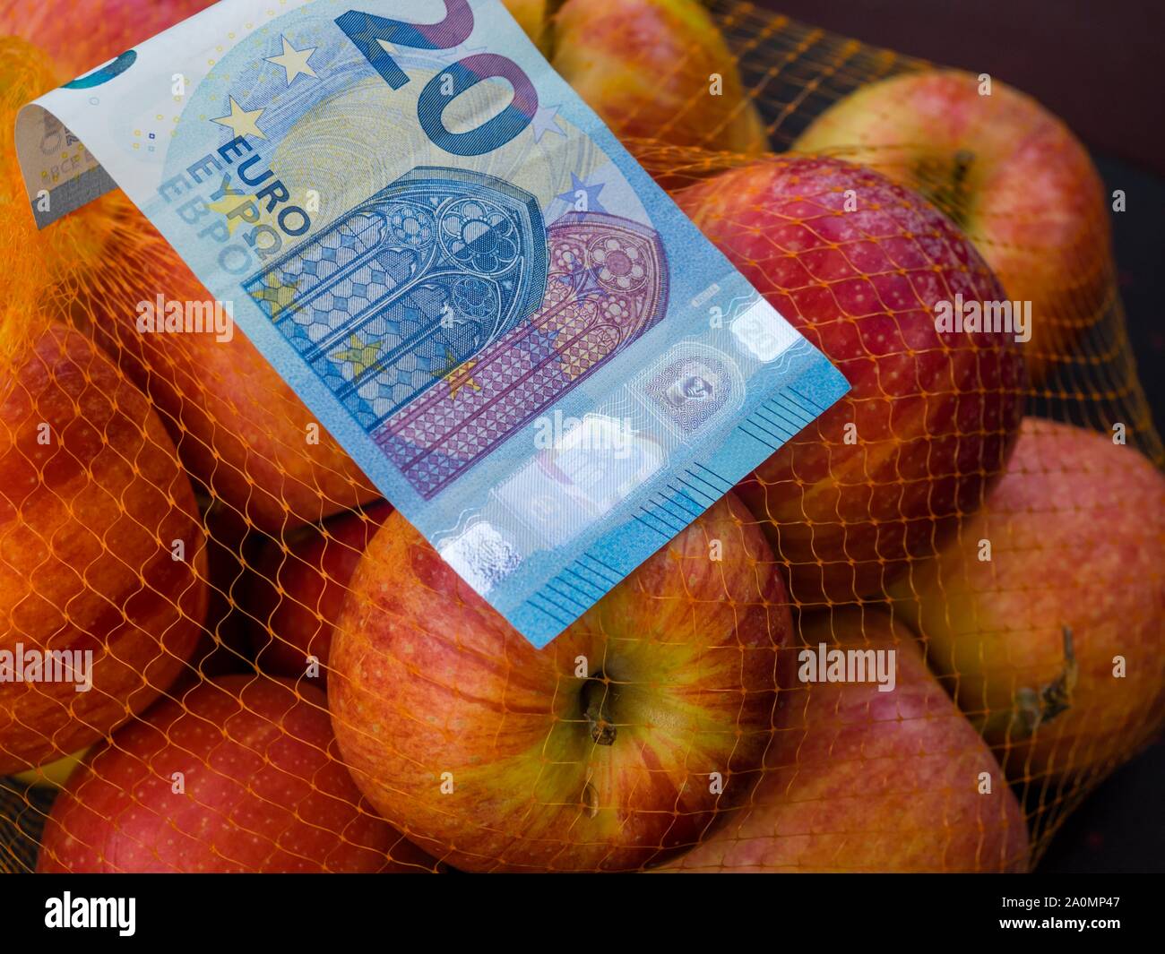 Apple fruit in backet and paper banknote money 20 twenty Euros Euro European Europe Stock Photo