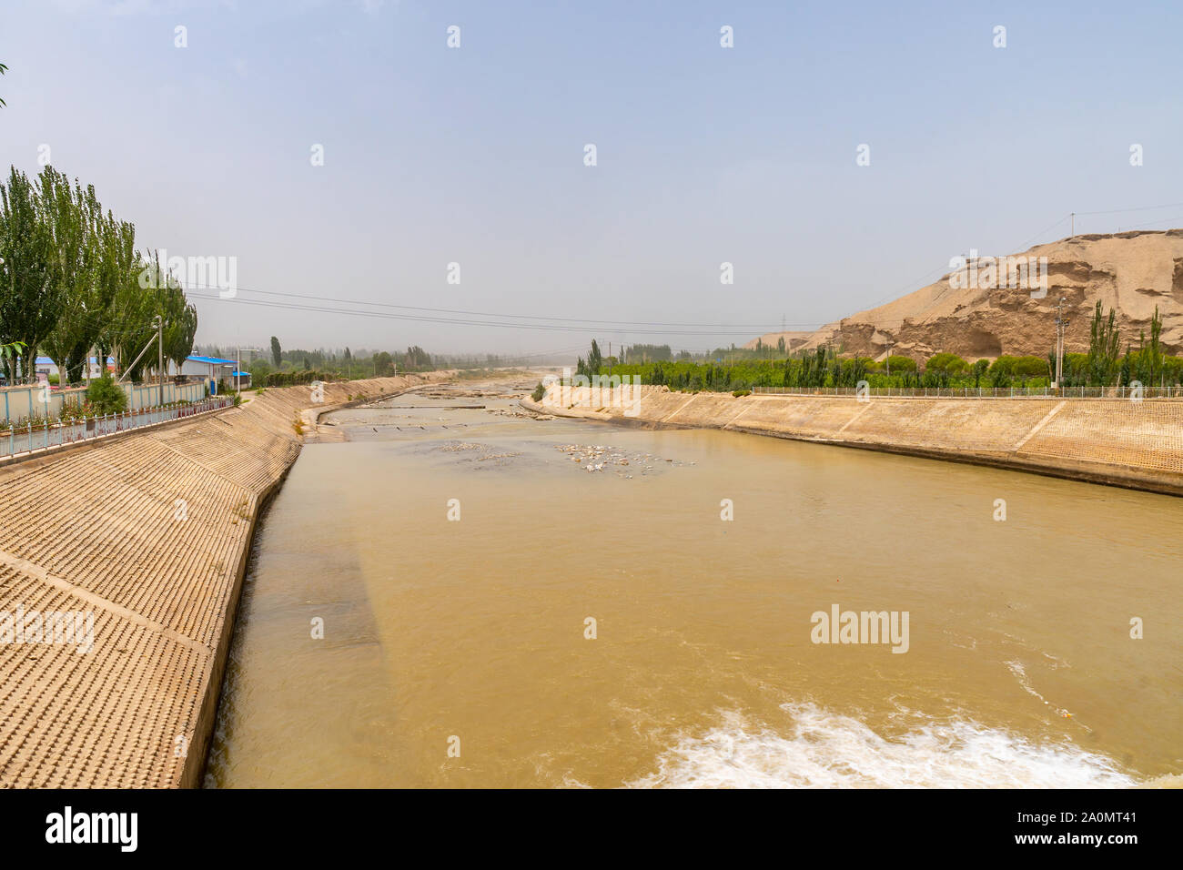 Karakash Black Jade River Dam View of the Streaming Water on a Sunny Blue Sky Day Stock Photo