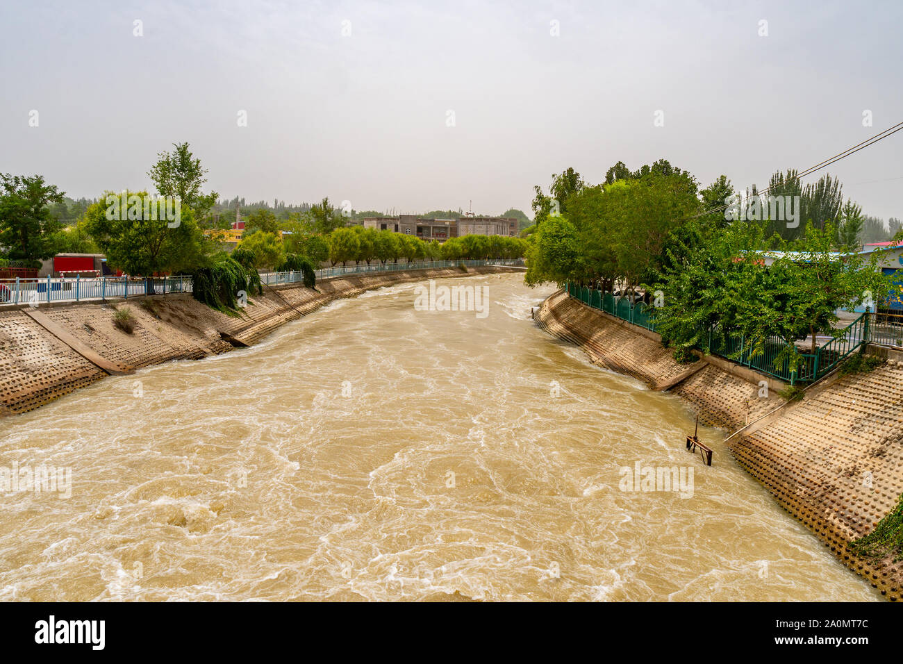 Karakash Black Jade River Dam View of the Streaming Water on a Sunny Blue Sky Day Stock Photo