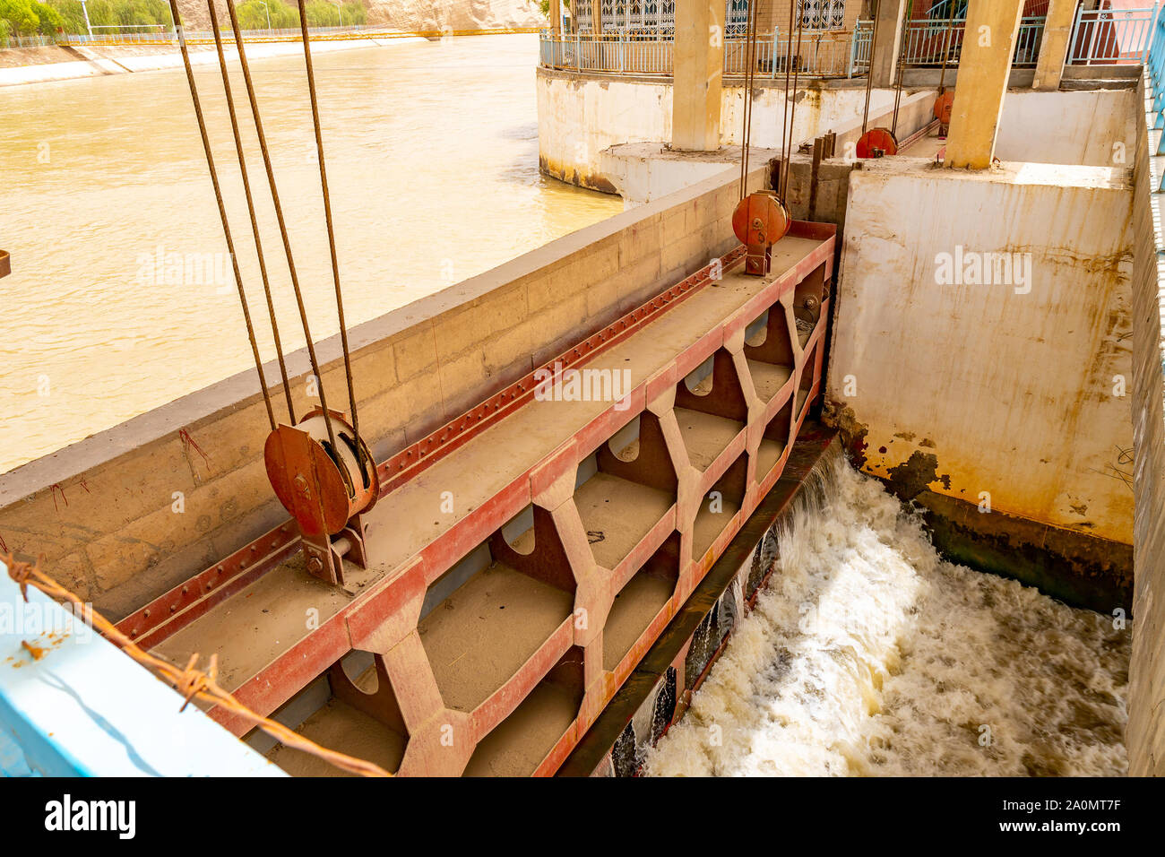 Karakash Black Jade River View of the Water Streaming through the Dam on a Sunny Blue Sky Day Stock Photo