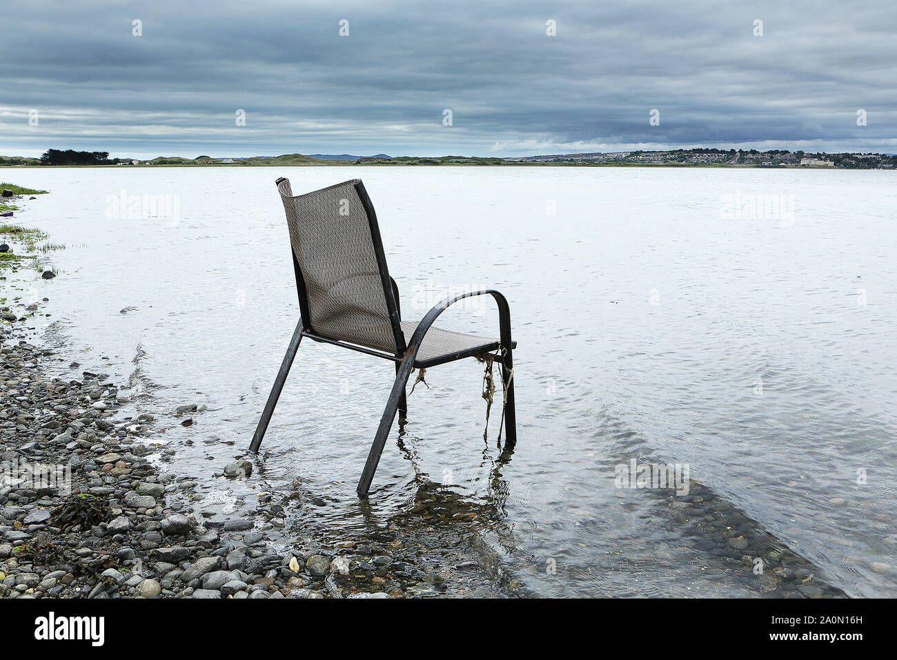 old chair at waters edge Stock Photo