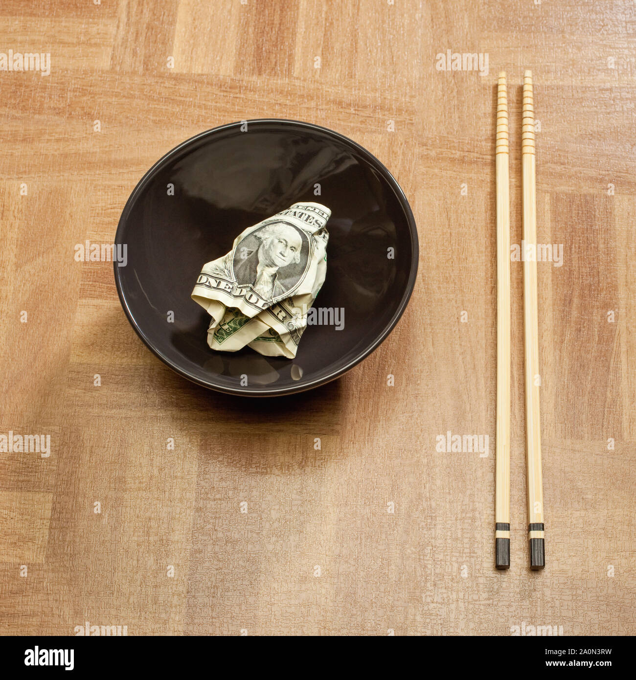 US dollar bill in a bowl with Chinese chopsticks – USA China trade concept Stock Photo