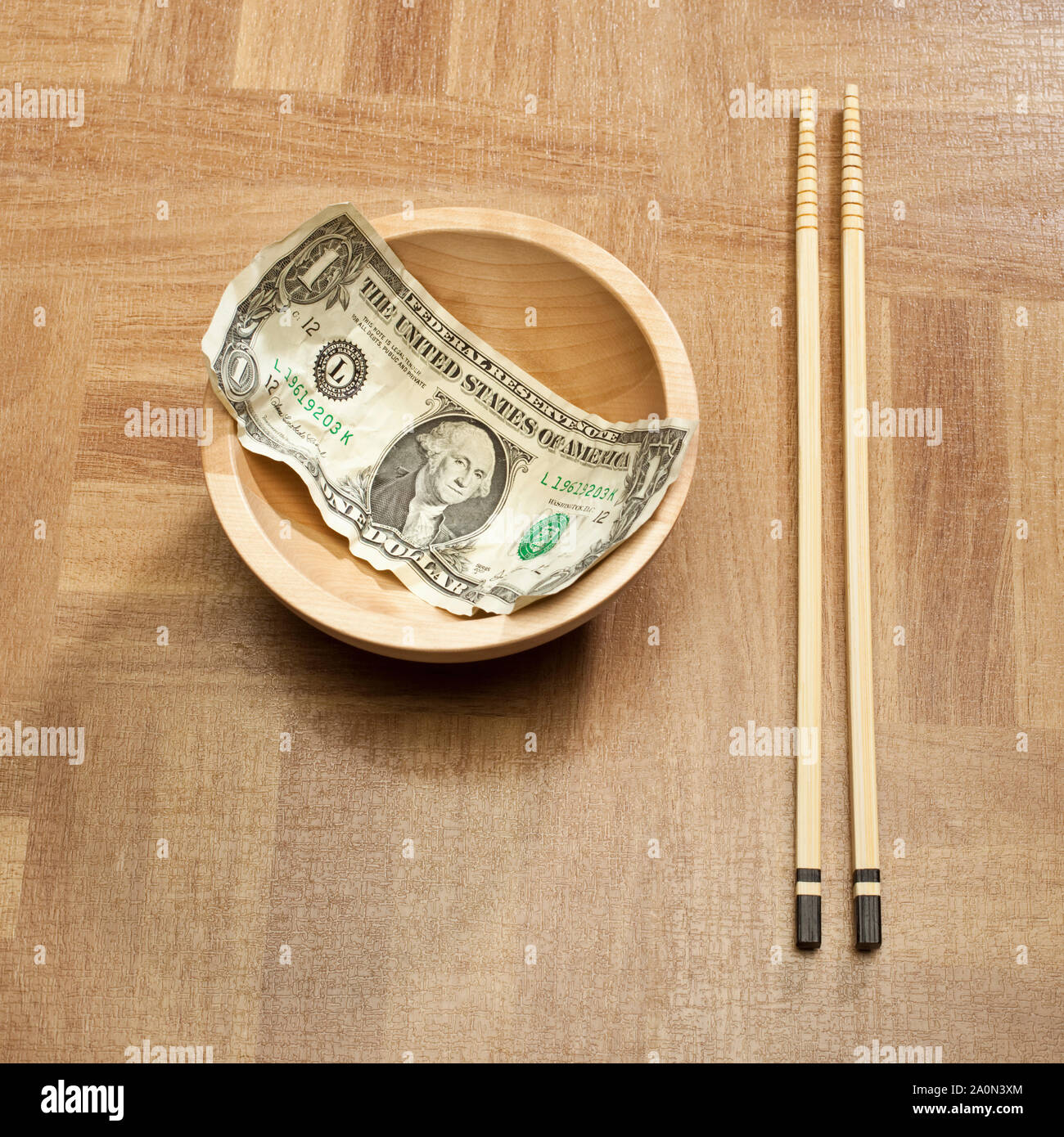 US dollar bill in a bowl with Chinese chopsticks – USA China trade concept Stock Photo