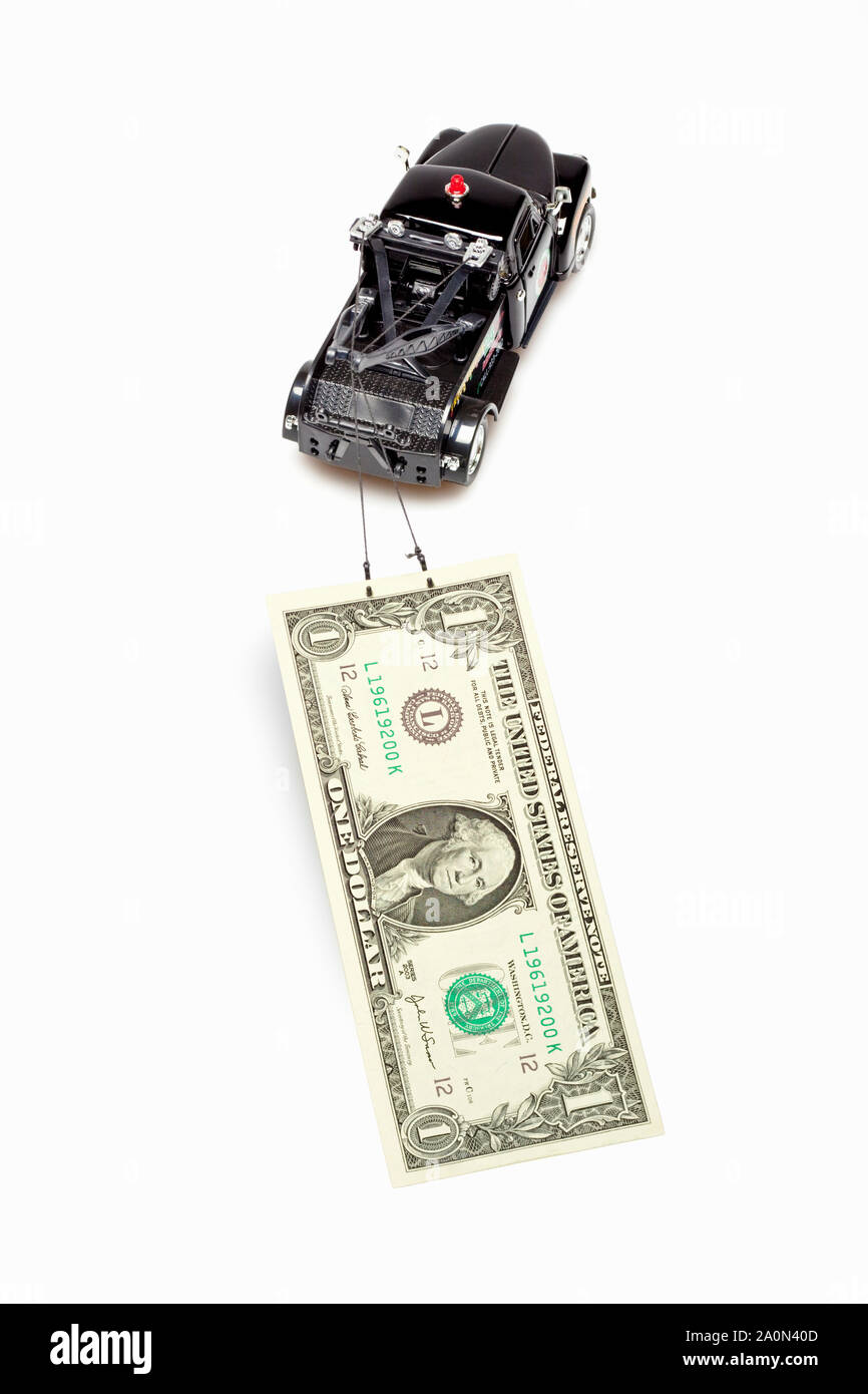 Tow truck towing a US dollar bill – debt recovery concept Stock Photo