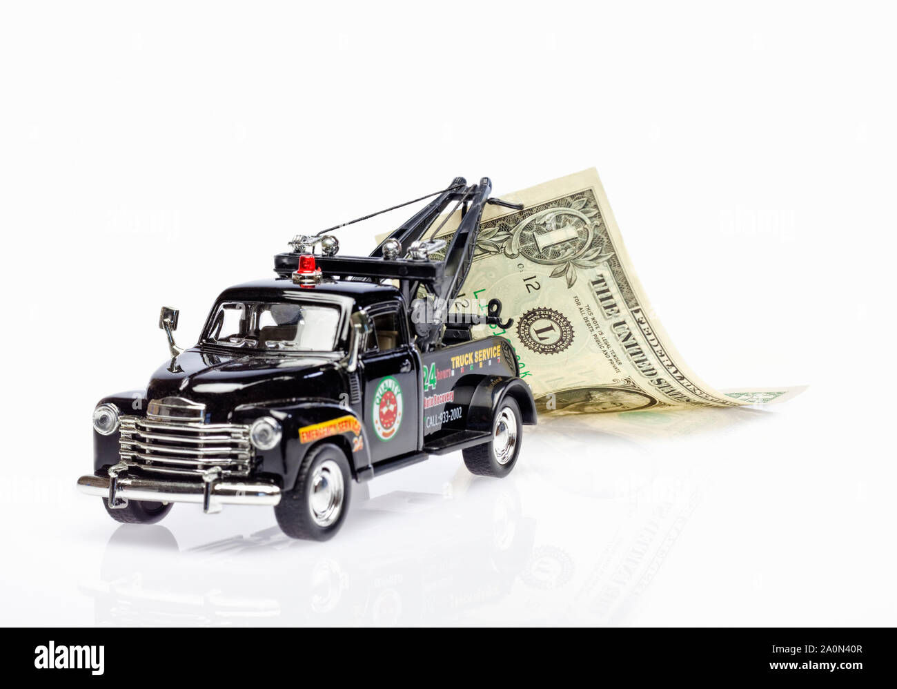 Tow truck towing a US dollar bill – debt recovery concept Stock Photo