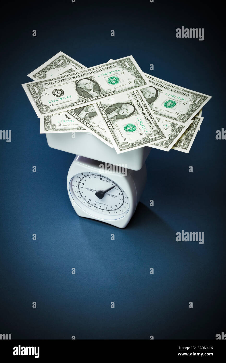 Weighing money (US Dollars) on scales – debt concept Stock Photo