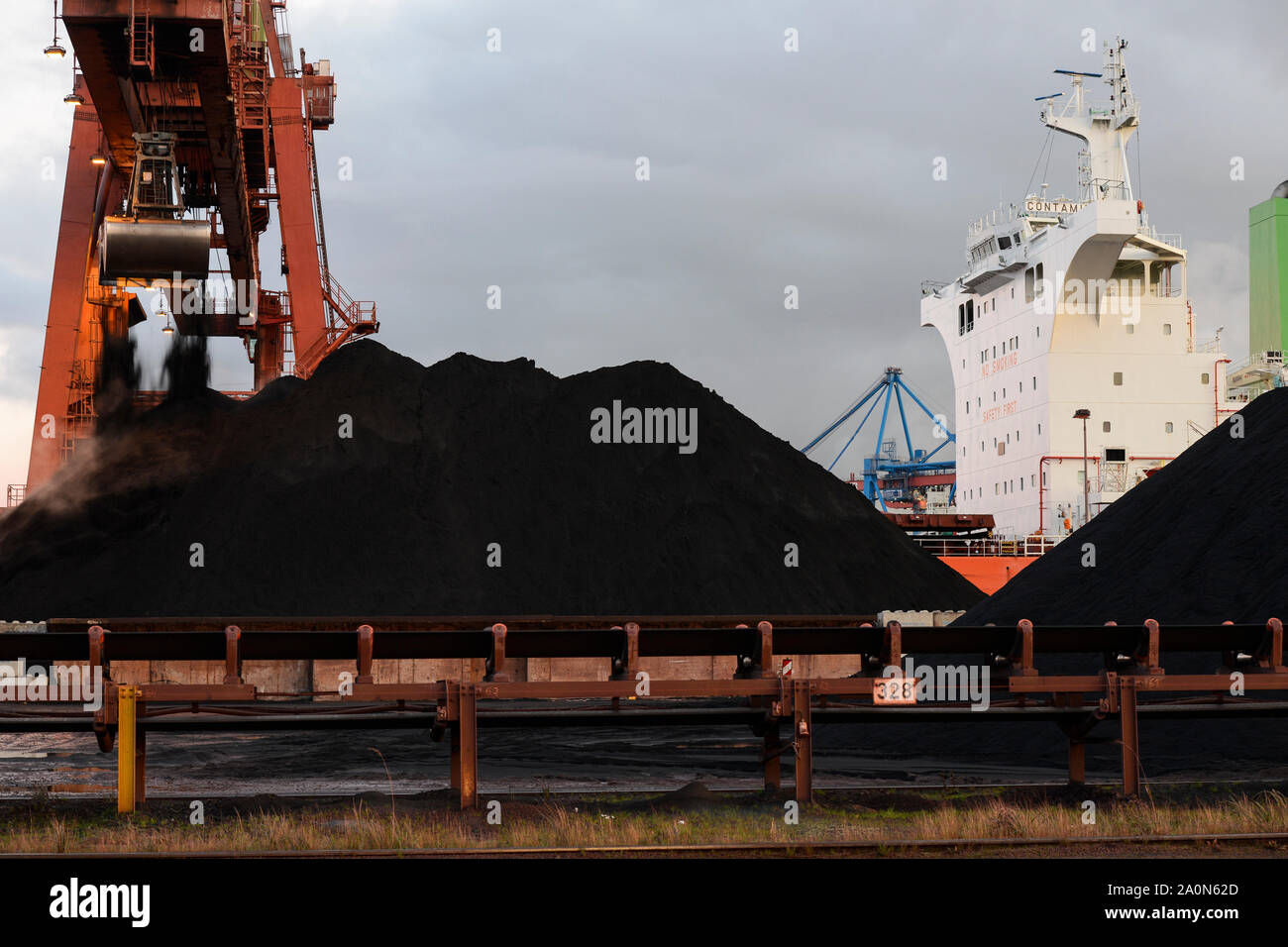 Germany, Hamburg, Hansaport import of coal and ore, unloading of cannadian coal from vessel Contamines with large excavator shovel / DEUTSCHLAND, Hamburg, Hansaport, Import von Kohle und Erz, Entladung von kannadischer Kohle vom Schiff Contamines Stock Photo