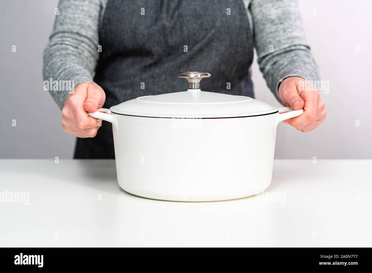 White enameled cast iron covered round dutch oven on a whjite background. Stock Photo