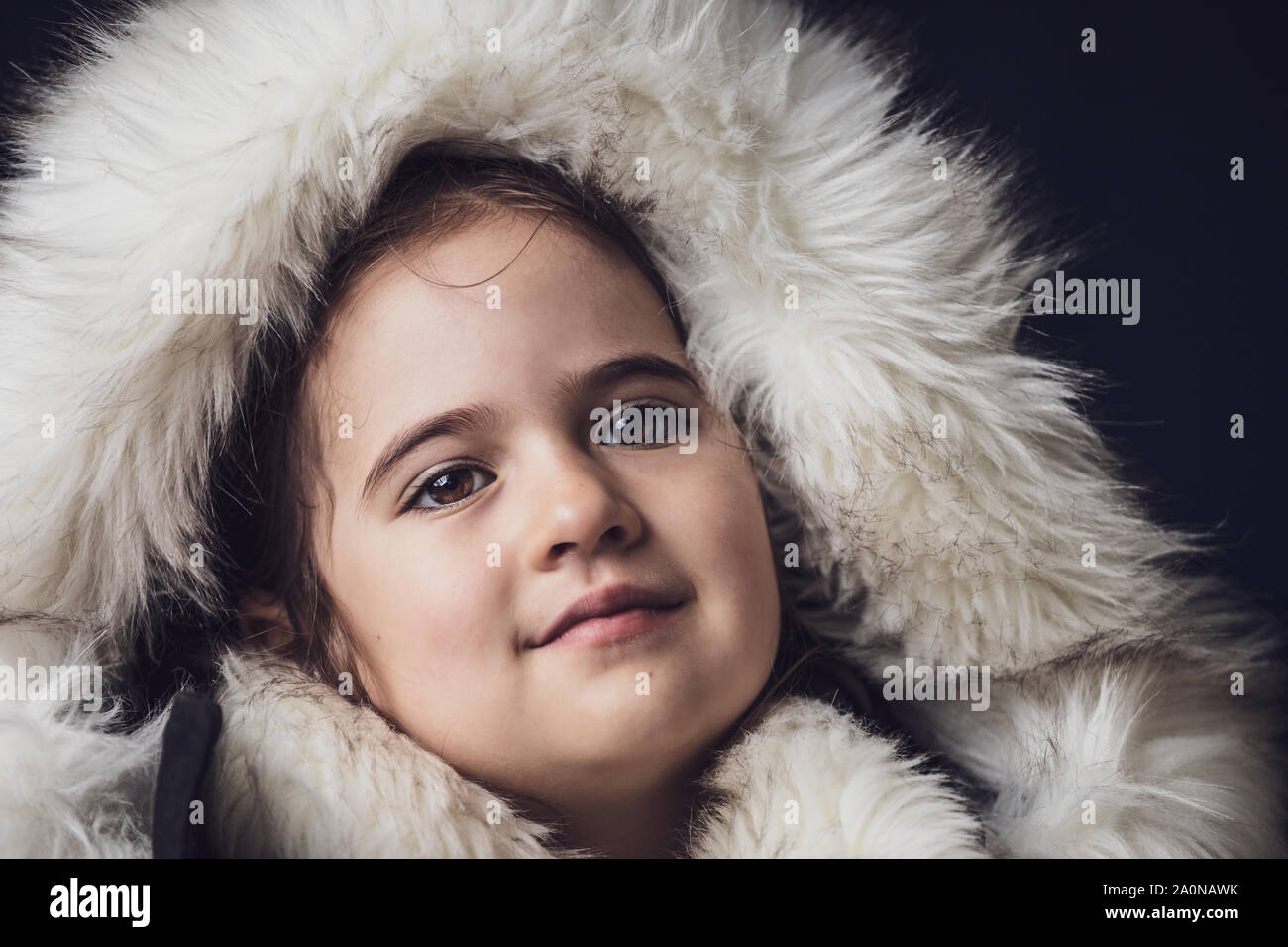 Close up portrait of a young girl dressed with an eskimo jacket looking