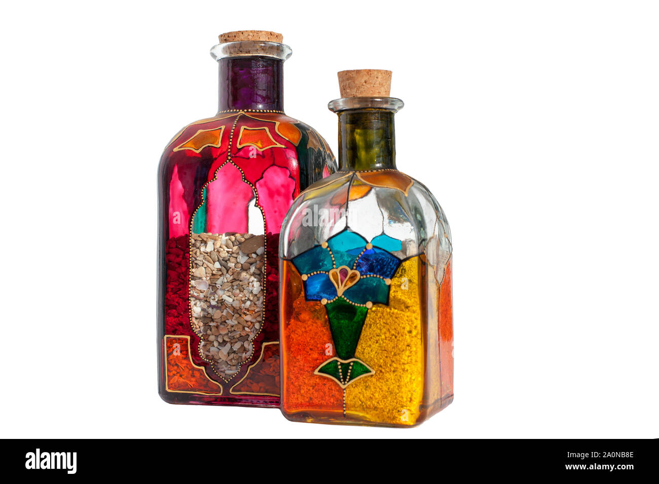 Bottles of multi-colored glass with a cork, inside the sand on white background isolated Stock Photo