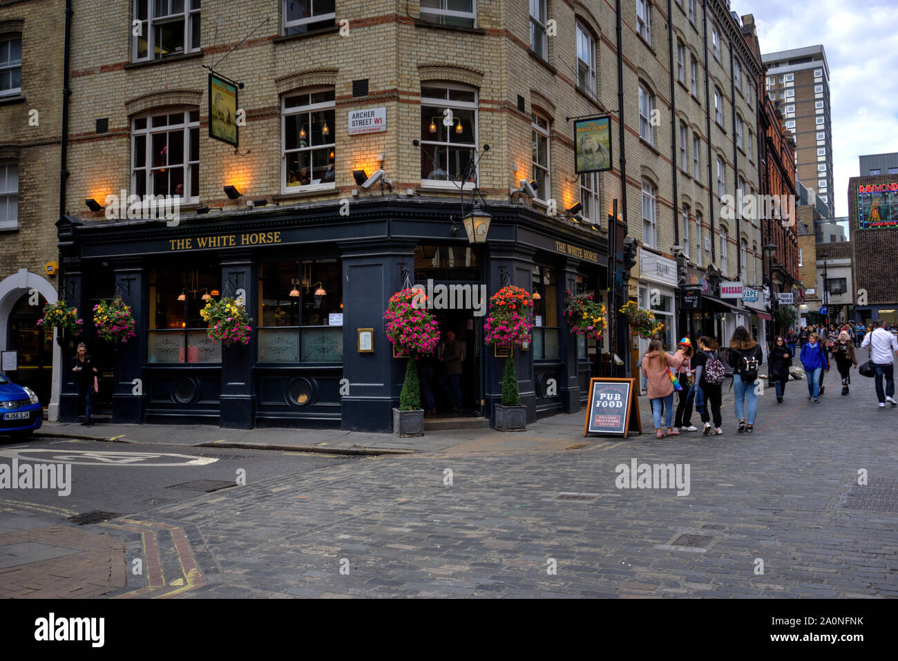 London, United Kingdom - September 7, 2019: The White Horse public house with many people outside some motion blurred and patrons inside Stock Photo