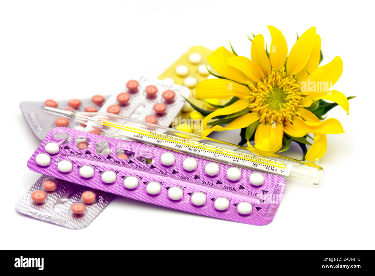 Oral contraceptive pills, Thermometer and sun flower on white background. Stock Photo