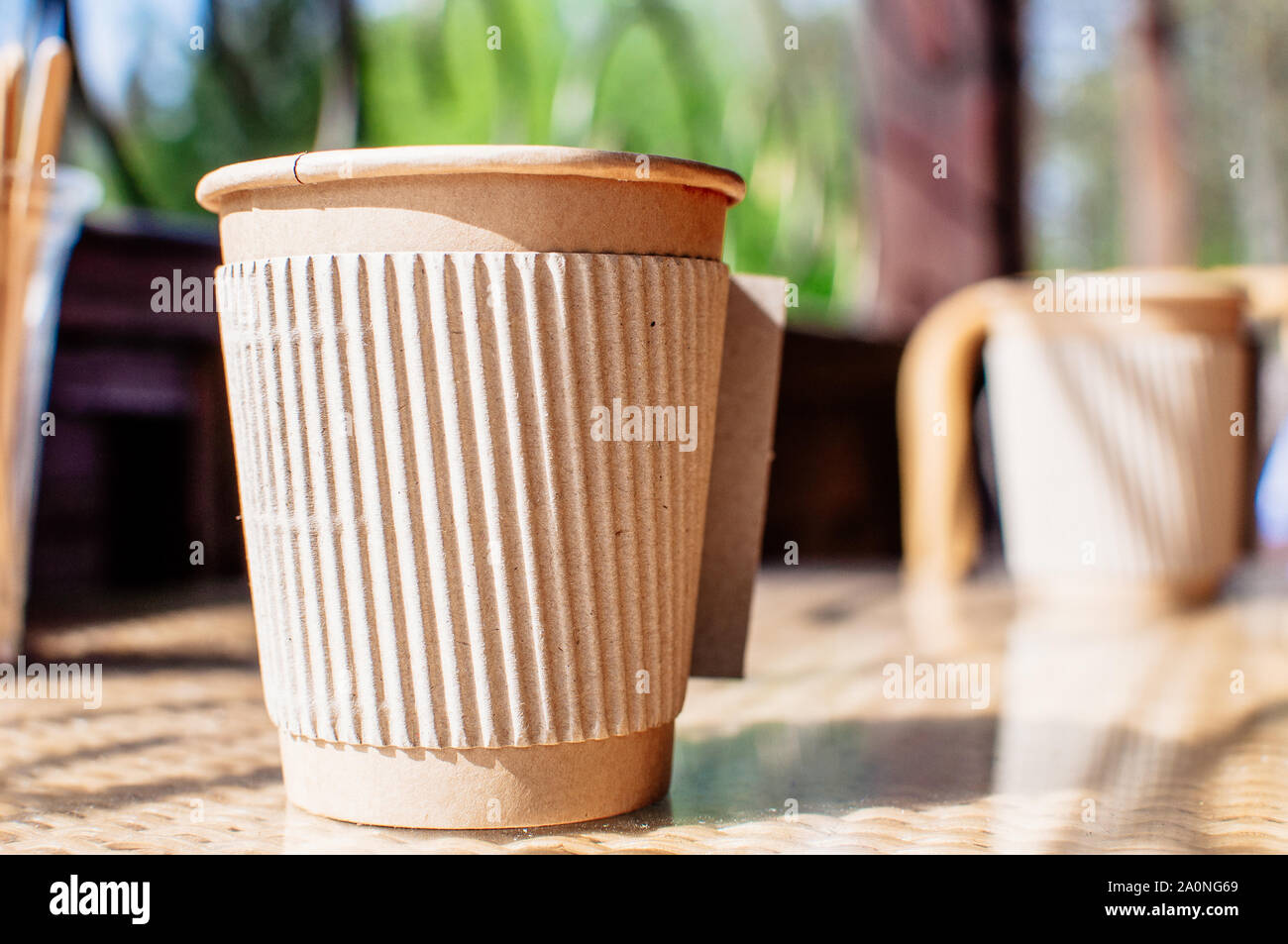 Disposable paper coffee cup with holder on table in cafe with wooden ...