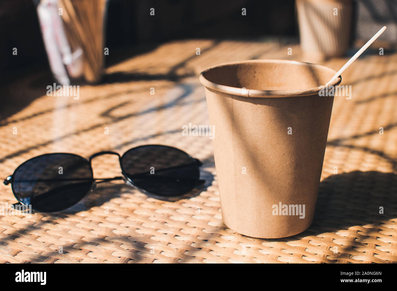 Disposable paper coffee cup on table in cafe with wooden stirrer,near ...