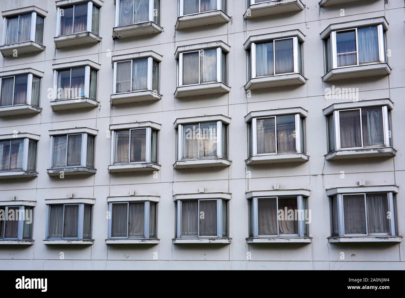Bay windows in an old apartment building repeat in four rows, all with