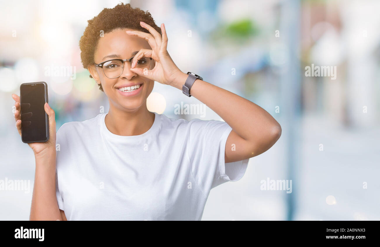 Young african american woman showing smartphone screen over isolated ...