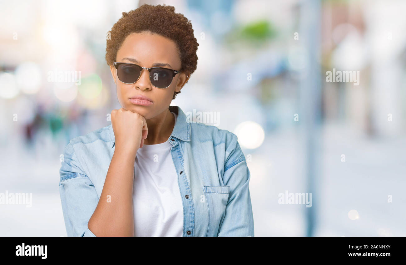 Beautiful young african american woman wearing sunglasses over isolated