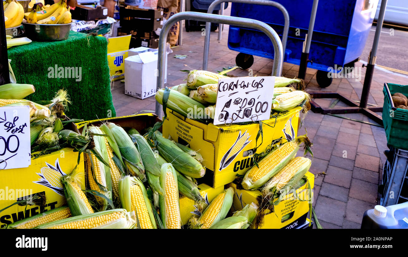 Market Trader Selling Frsh Ripe Corn on the Cob or Sweetcorn Stock Photo