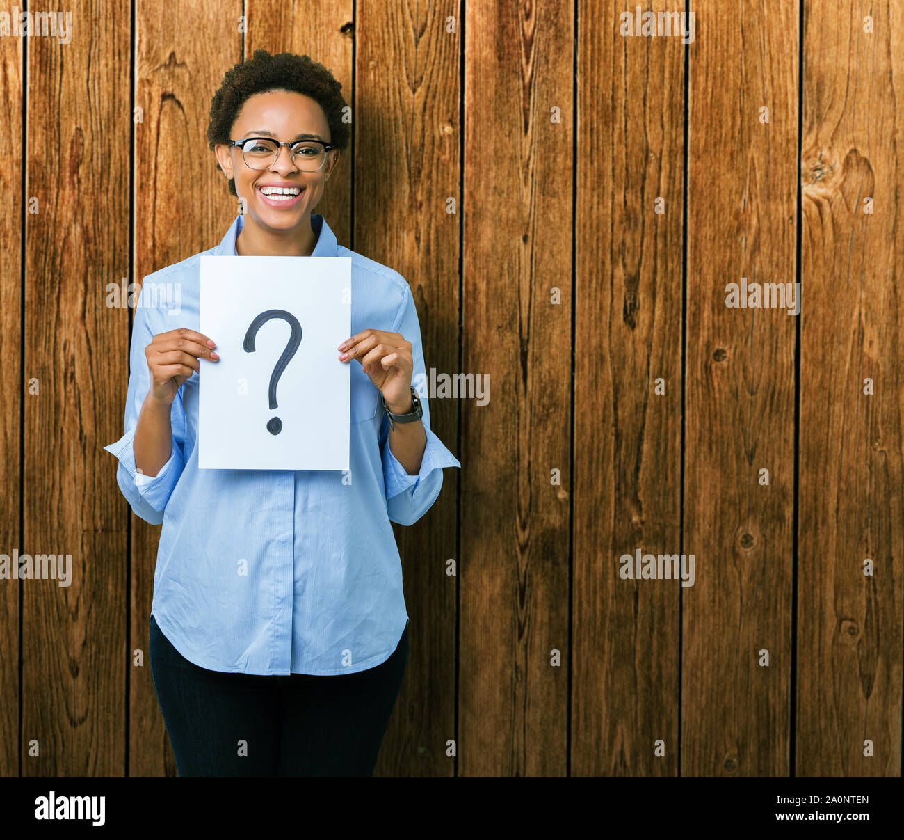 Young african american woman holding paper with question mark over ...