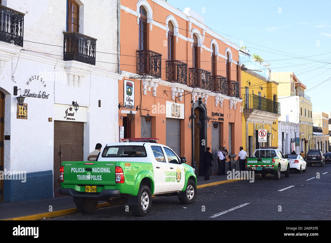 AREQUIPA, PERU - SEPTEMBER 9, 2014: Unidentified people on Jerusalen street with two tourism police pickups standing on the roadside in Arequipa, Peru Stock Photo