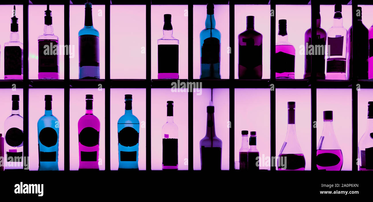 Various hard alcohol bottles in a bar, back lighting, toned image Stock Photo