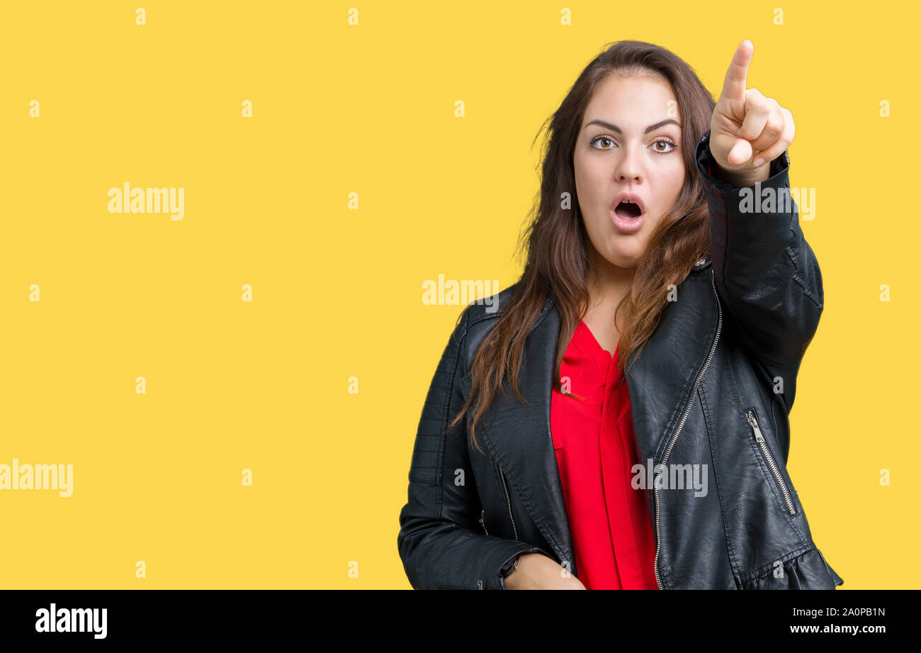 Beautiful plus size young woman wearing a fashion leather jacket over  isolated background Pointing with finger surprised ahead, open mouth amazed  expr Stock Photo - Alamy