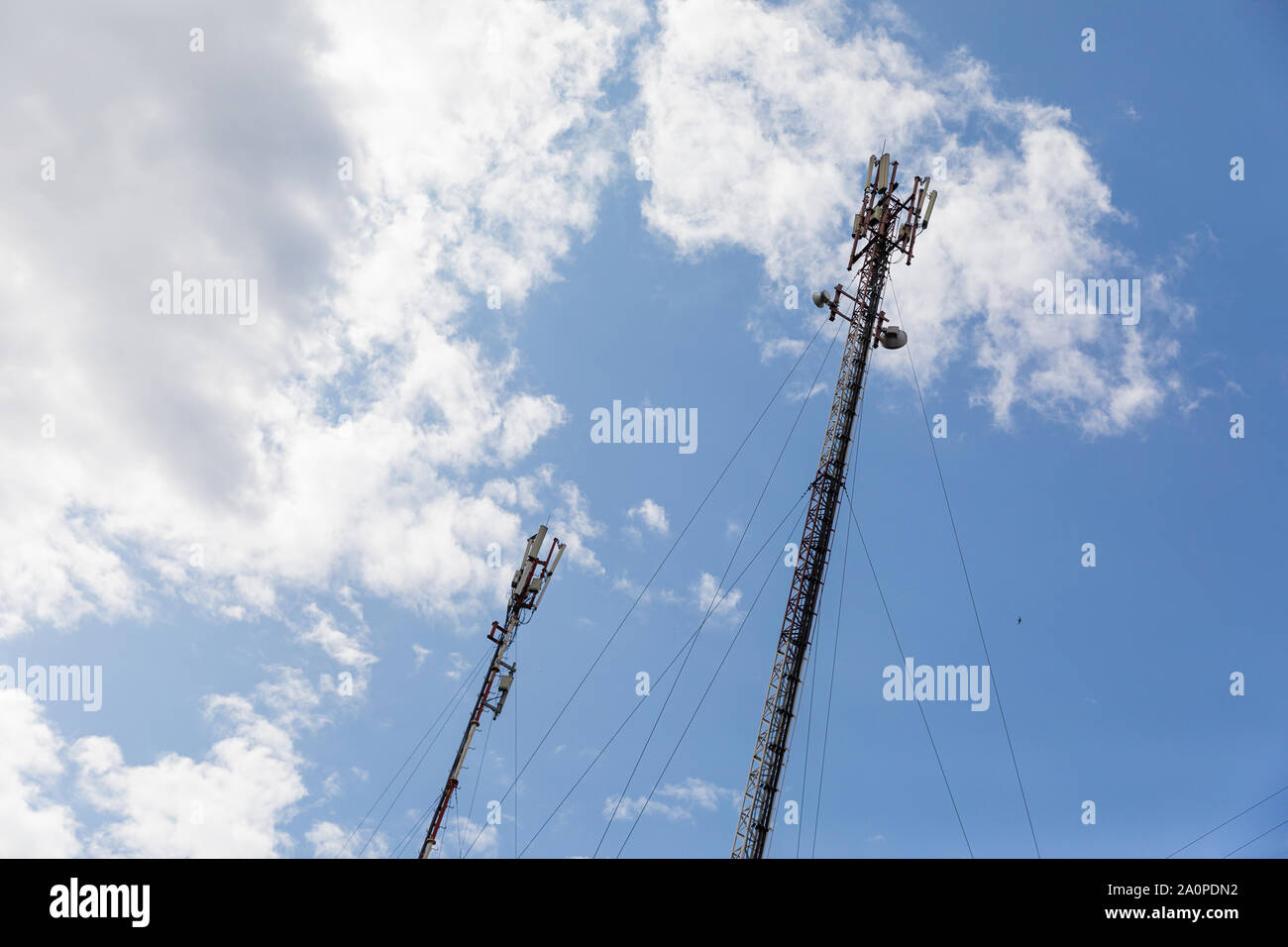 Red and white mobile phone cell tower repeater, with a small microwave