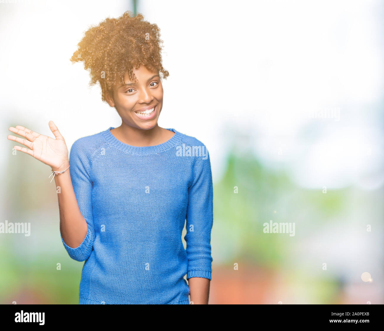 Beautiful young african american woman over isolated background Waiving ...