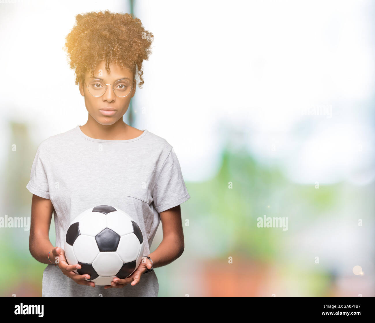 Young african american woman holding soccer football ball over isolated ...
