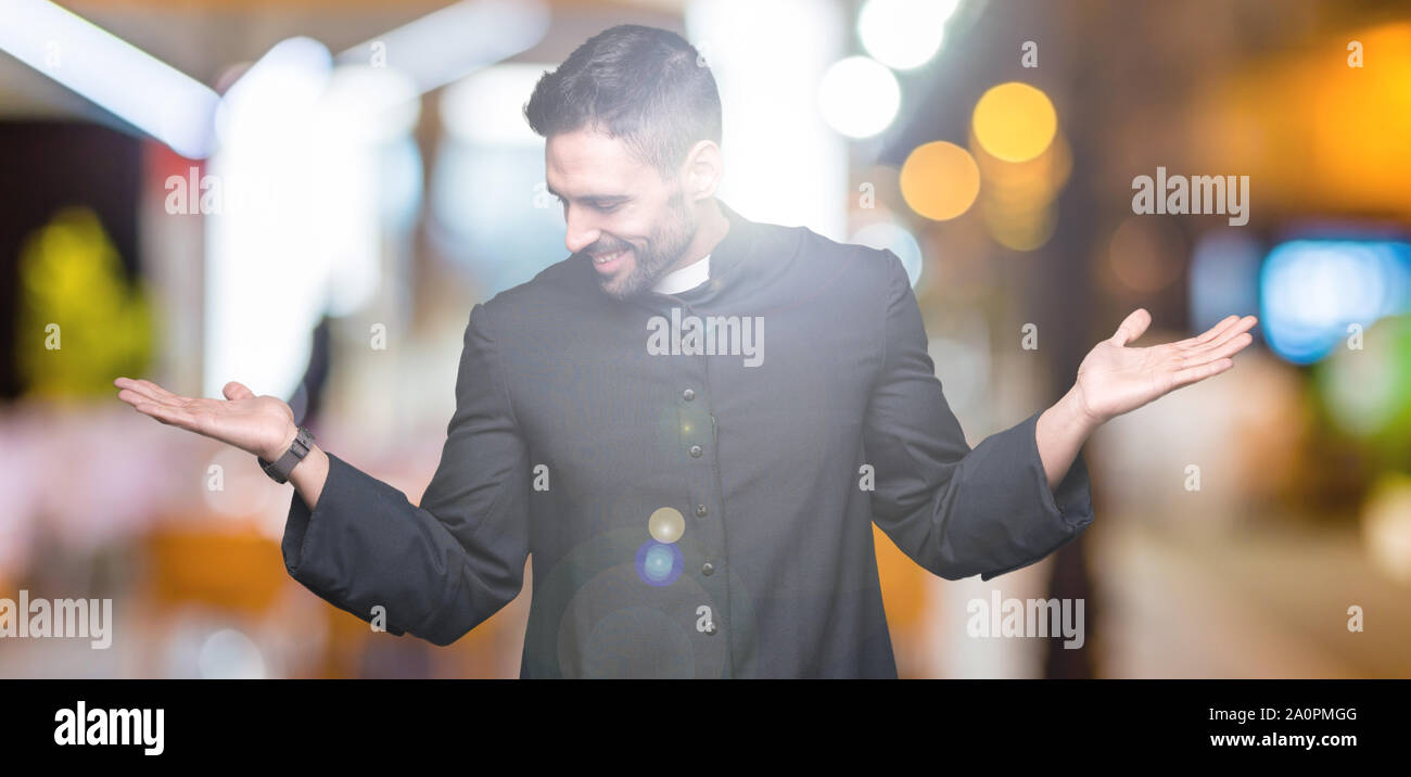 Young Christian priest over isolated background Smiling showing both ...