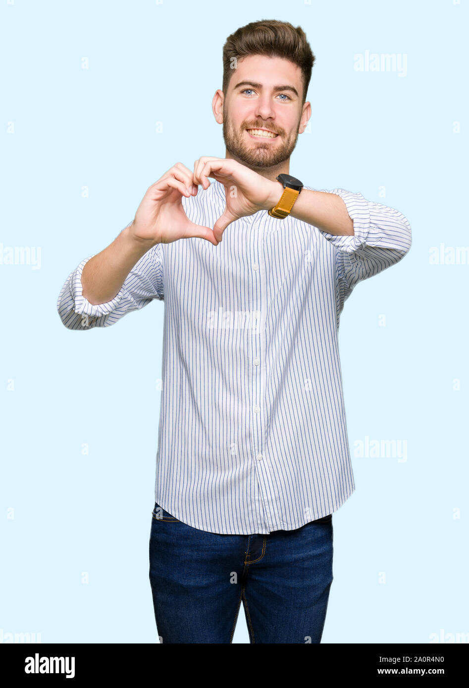 Young handsome man smiling in love showing heart symbol and shape with ...