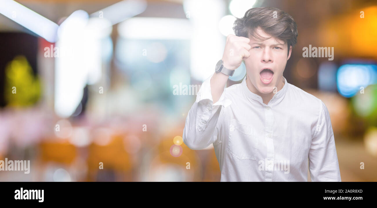 Young handsome business man over isolated background angry and mad ...