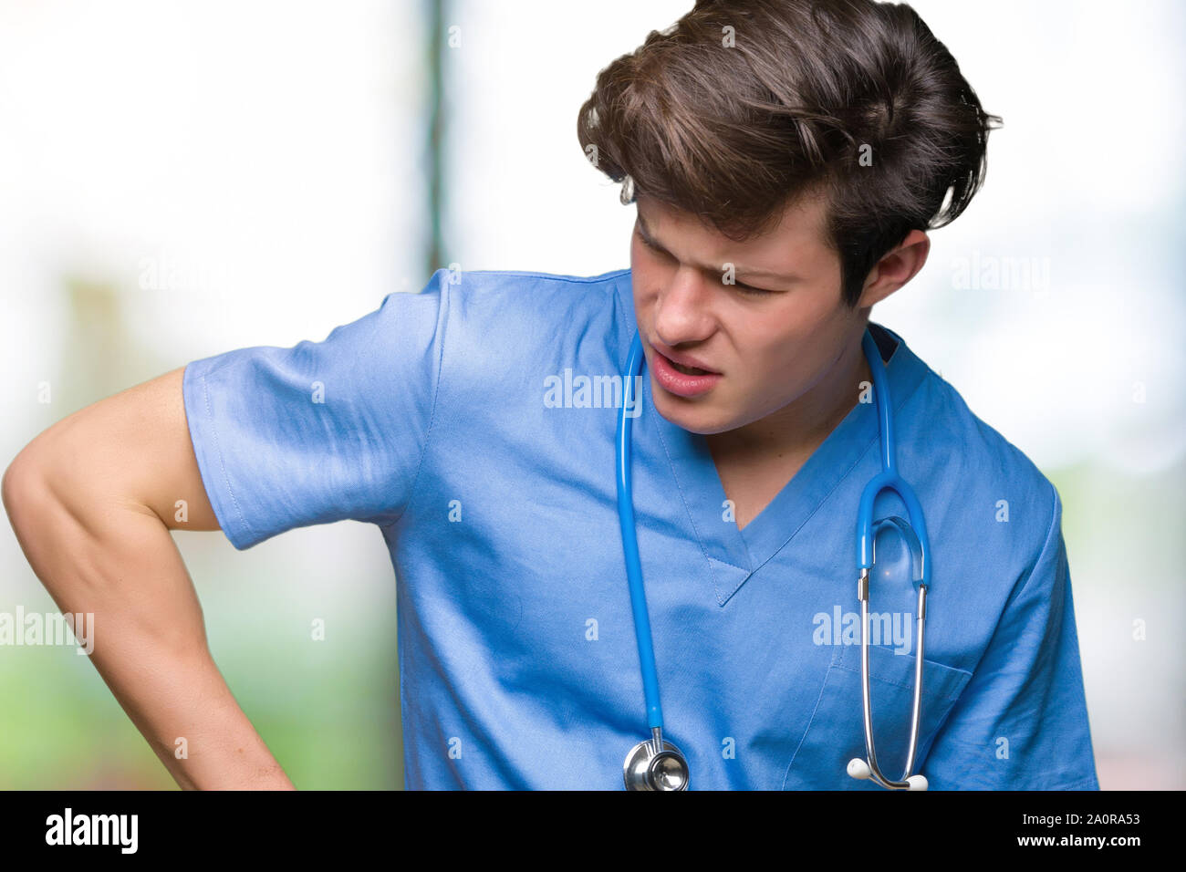 Young doctor wearing medical uniform over isolated background Suffering ...