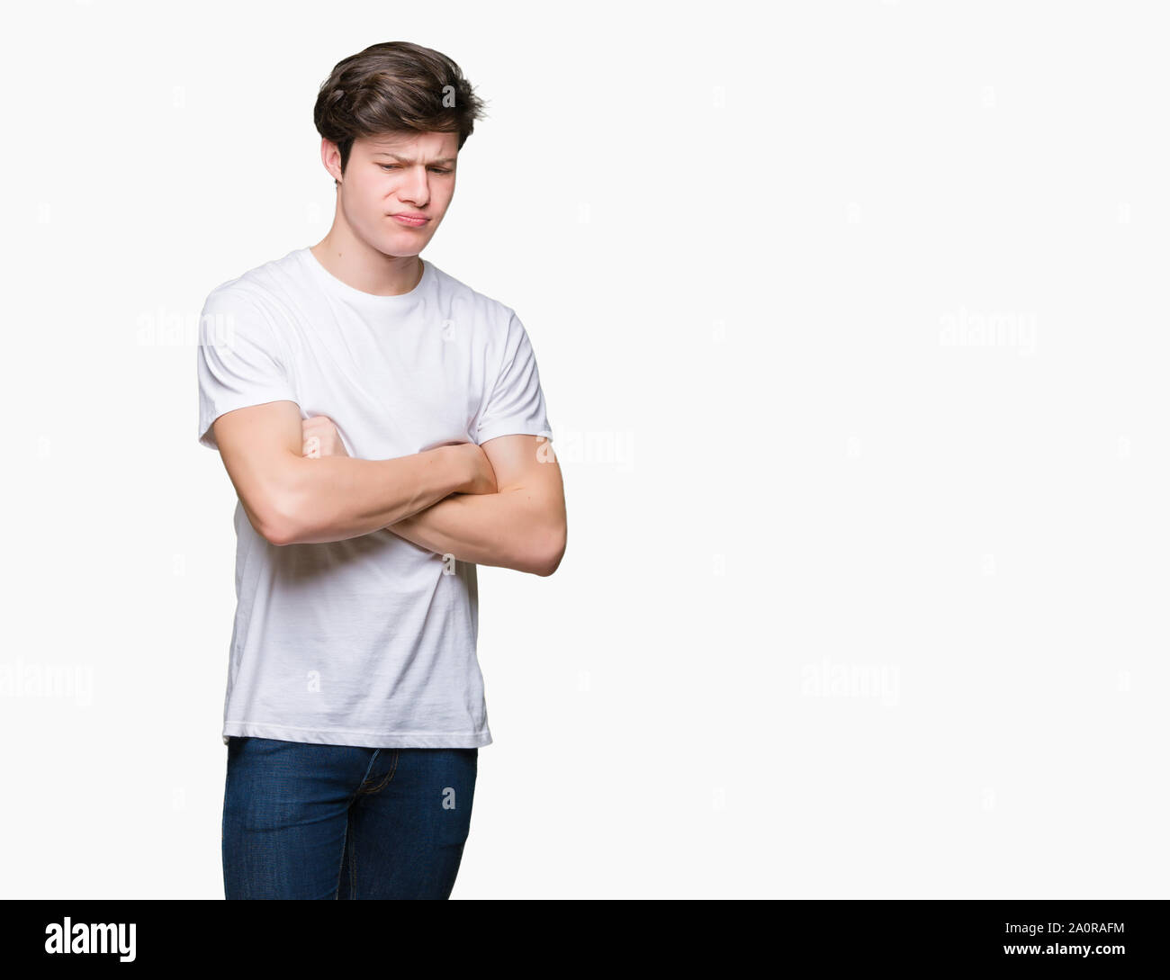 Young handsome man wearing casual white t-shirt over isolated background skeptic and nervous, disapproving expression on face with crossed arms. Negat Stock Photo