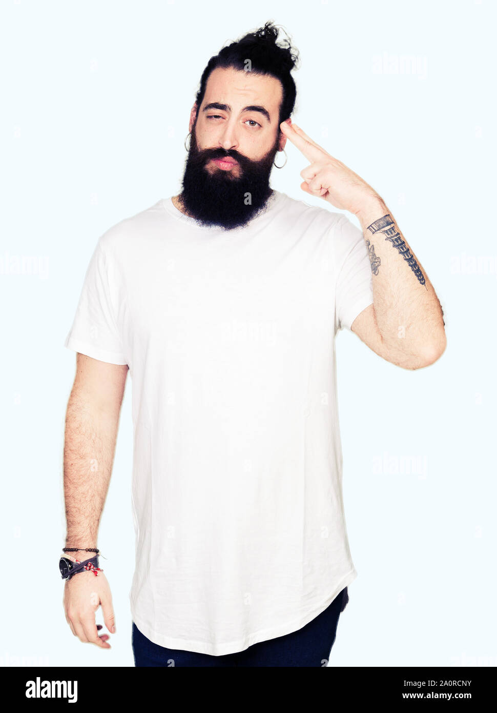 Young hipster man with long hair and beard wearing casual white t-shirt  Shooting and killing oneself pointing hand and fingers to head, suicide  gestur Stock Photo - Alamy