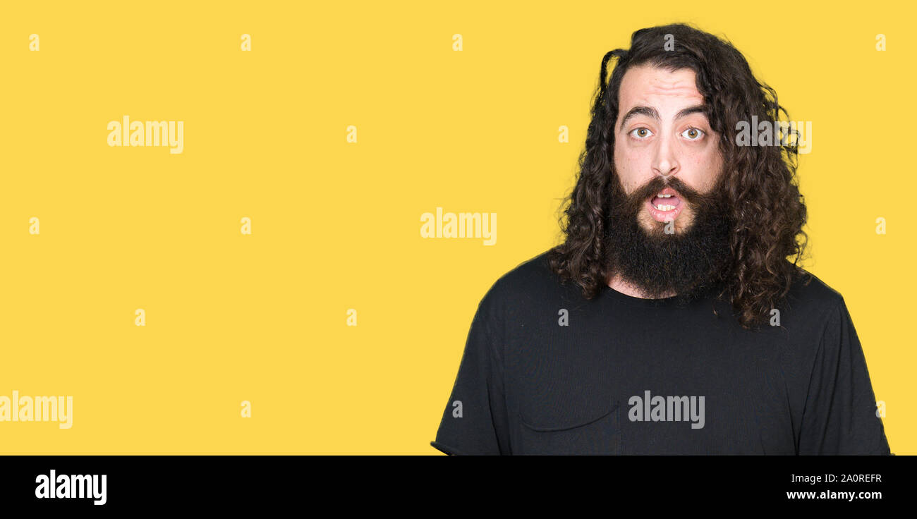 Young man with long hair and beard wearing heavy metal black outfit ...