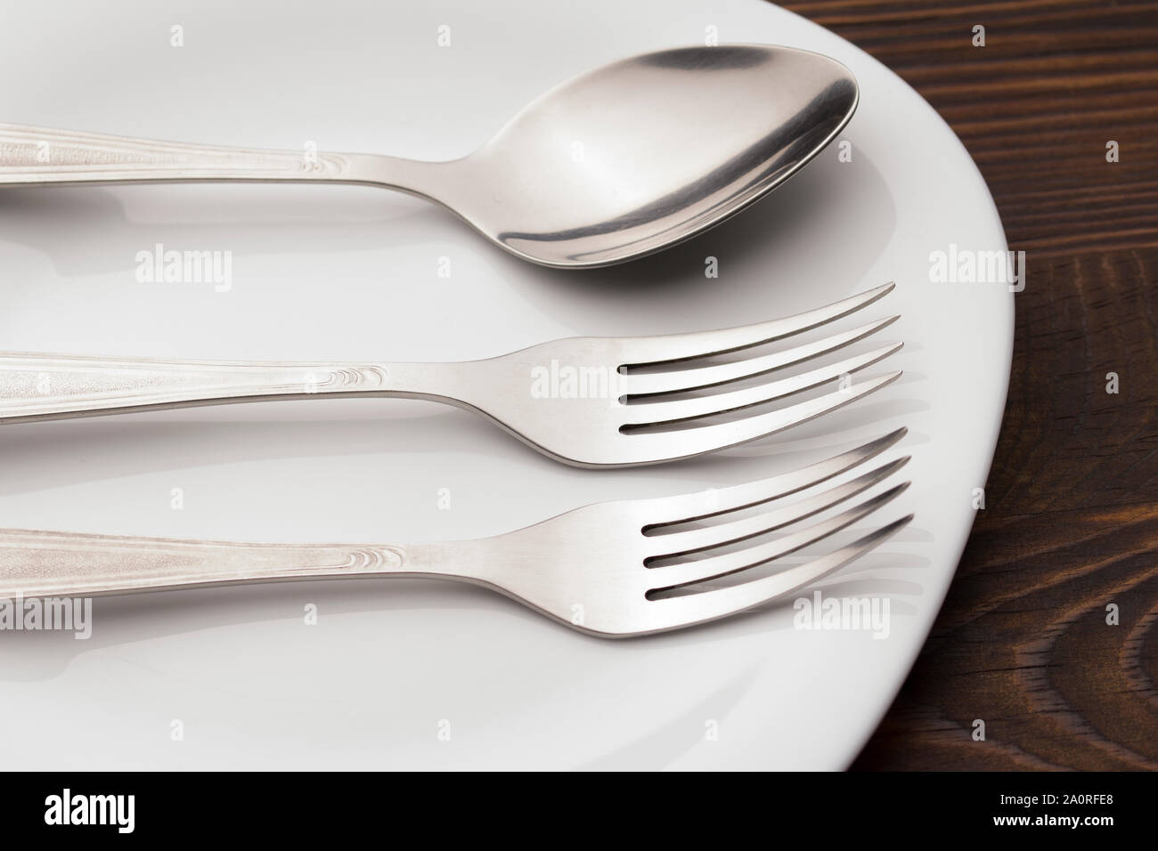 Fork And spoon on Plate On wood table . Dishes and cutlery. Stock Photo