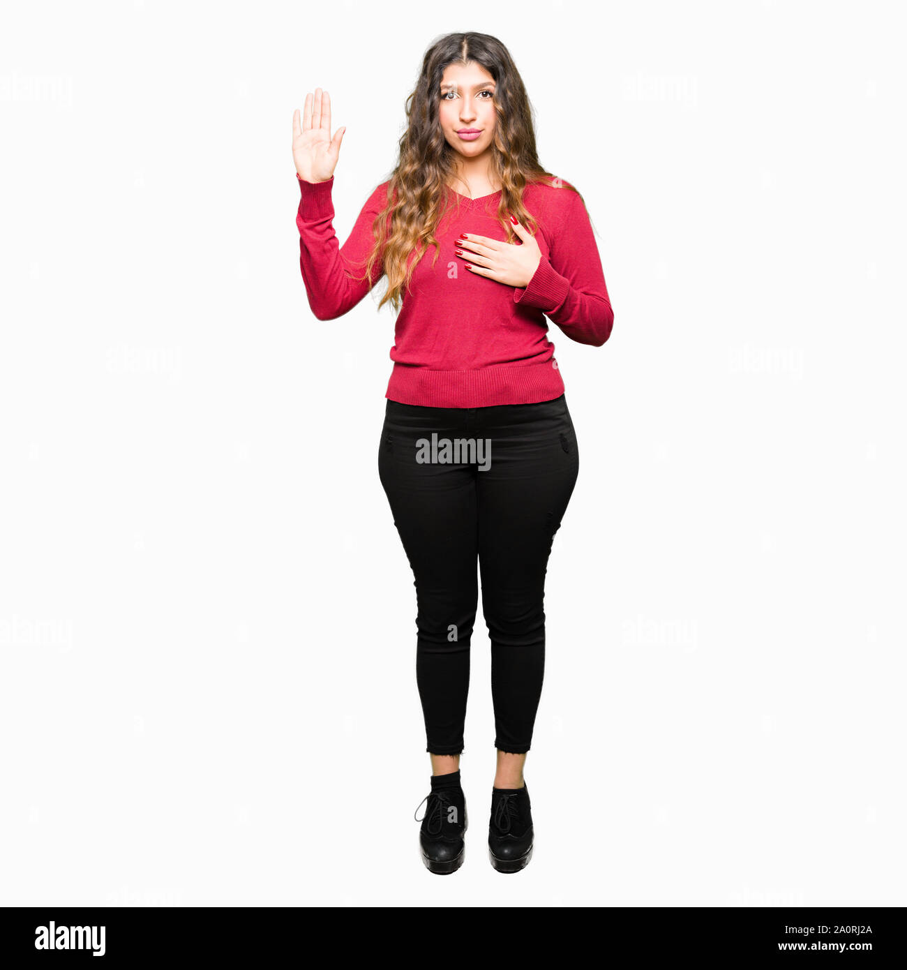 Young beautiful woman wearing red sweater Swearing with hand on chest and open palm, making a loyalty promise oath Stock Photo