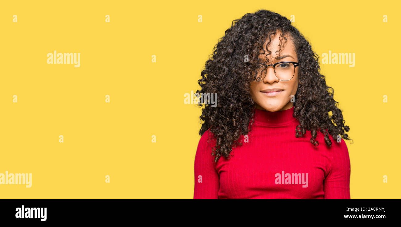 Young Beautiful Woman With Curly Hair Wearing Glasses With Serious