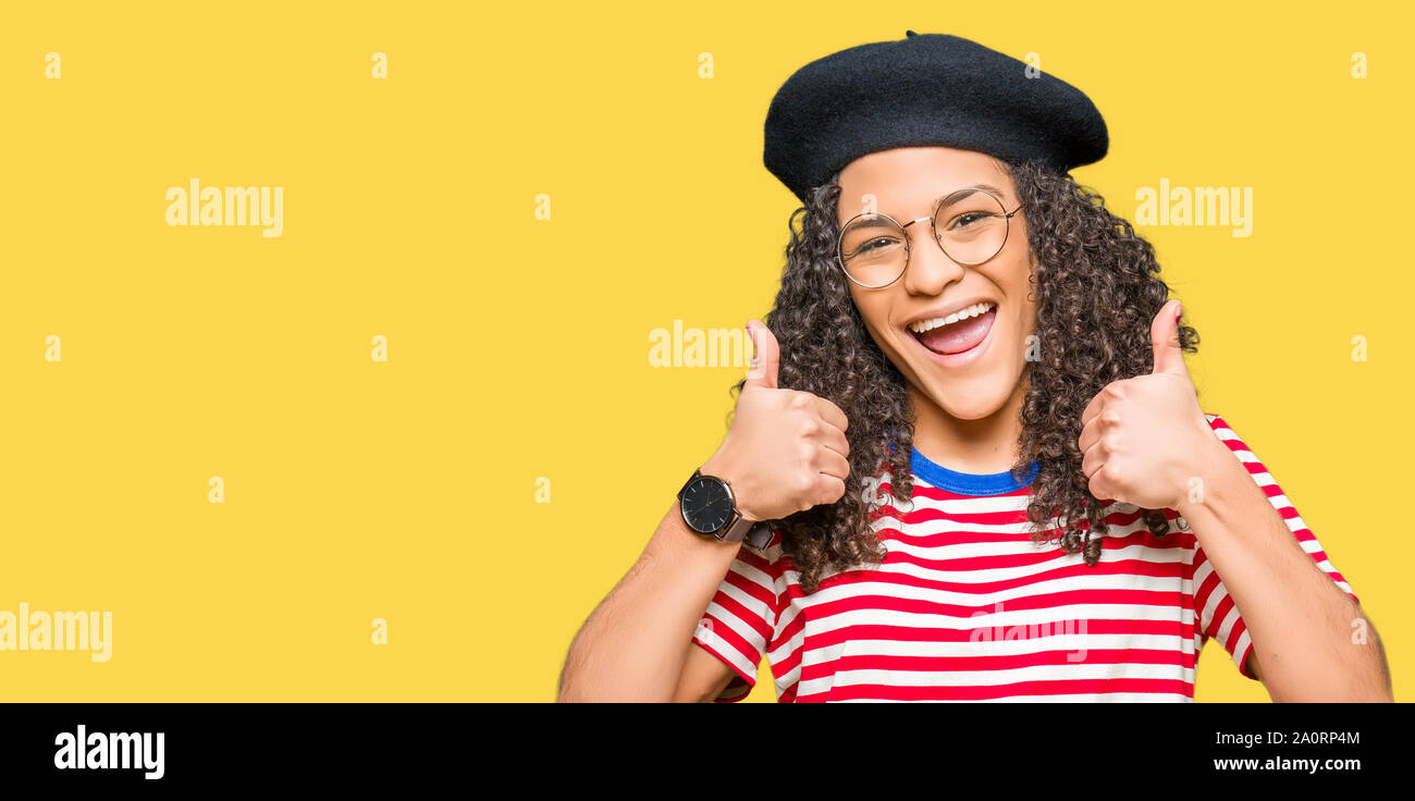 Young beautiful woman with curly hair wearing glasses and fashion beret ...