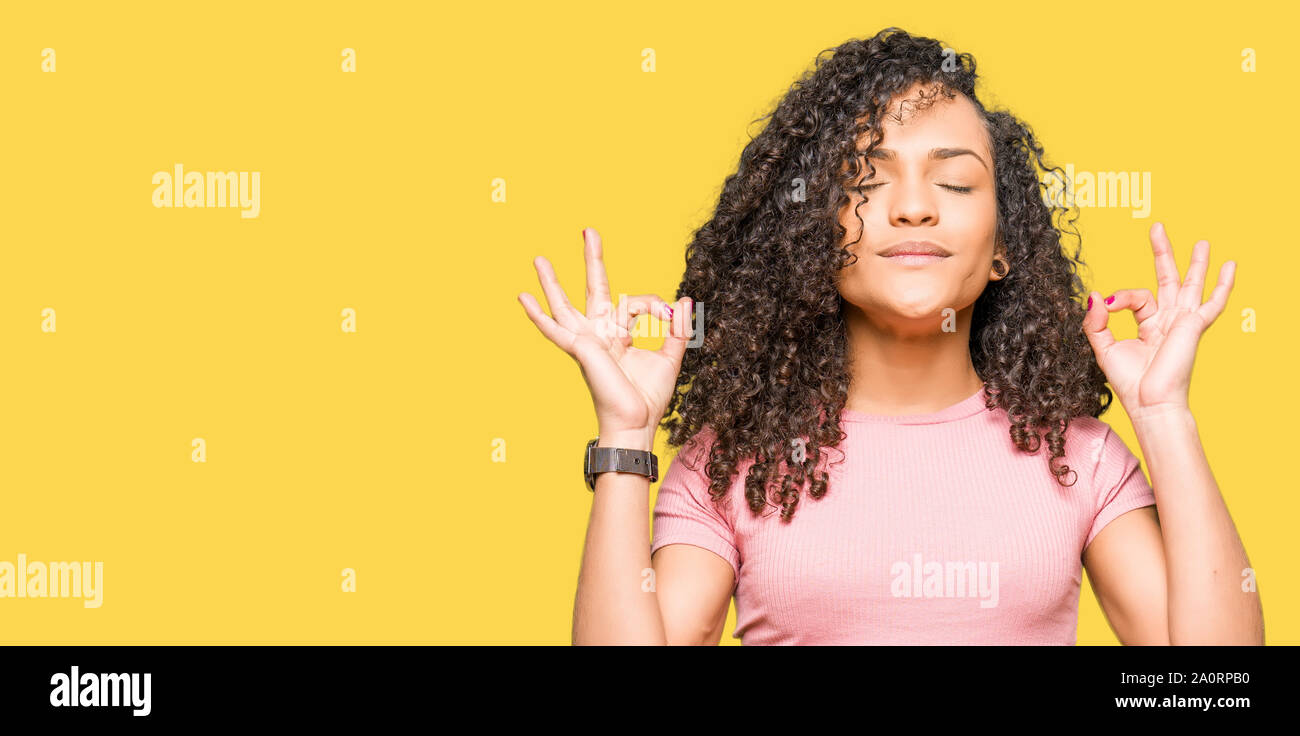 Young Beautiful Woman With Curly Hair Wearing Pink T Shirt Relax