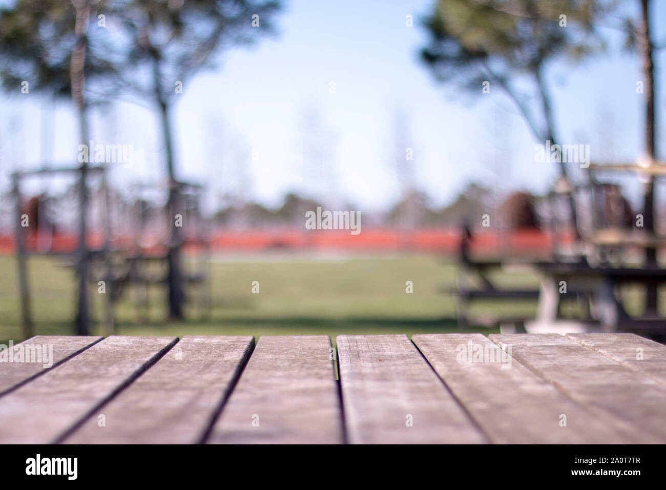 Empty table covered with sackcloth over blurred trees with bokeh background Stock Photo