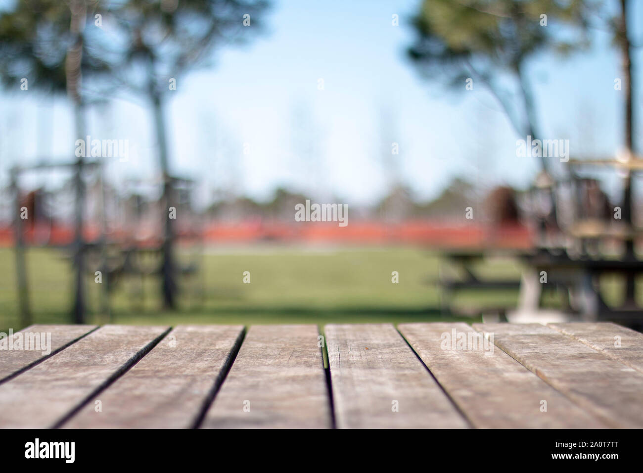 Empty table covered with sackcloth over blurred trees with bokeh background Stock Photo
