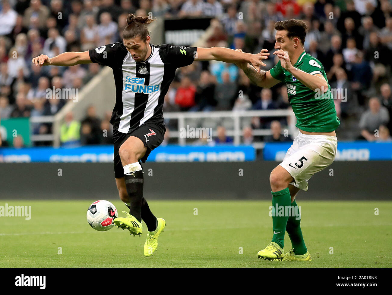 Newcastle United's Andy Carroll (left) and Brighton and Hove Albion's Lewis Dunk (right) battle for the ball during the Premier League match at St James' Park, Newcastle. Stock Photo
