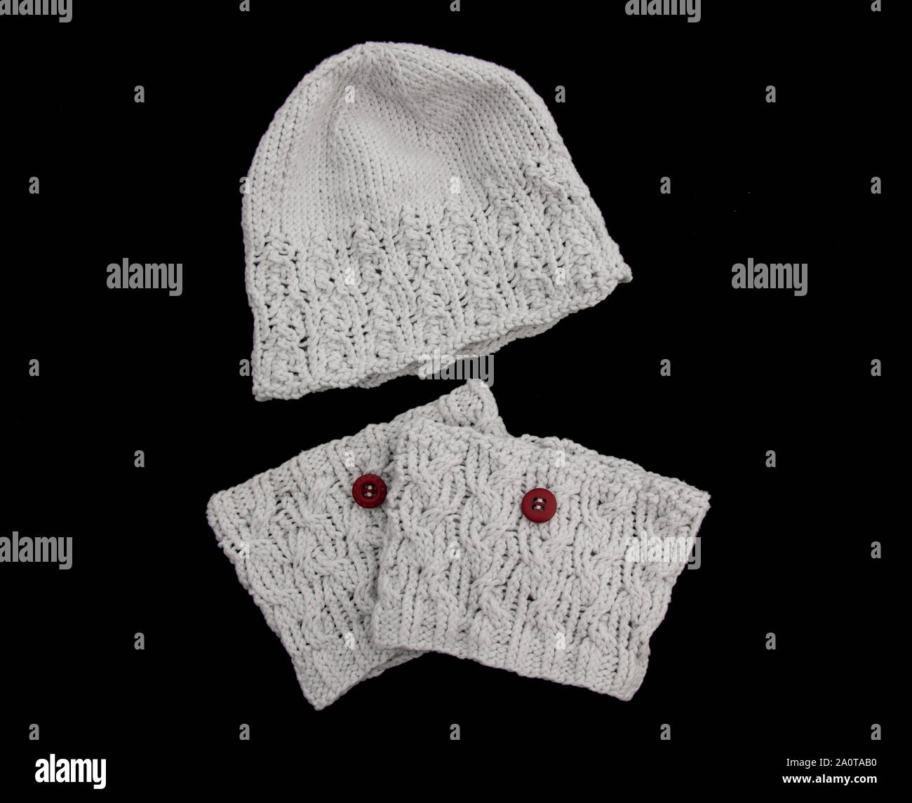 Light gray hat and boot topper fashion accessories with brick red colored buttons, isolated on a black background.  Fashion style for women for fall. Stock Photo