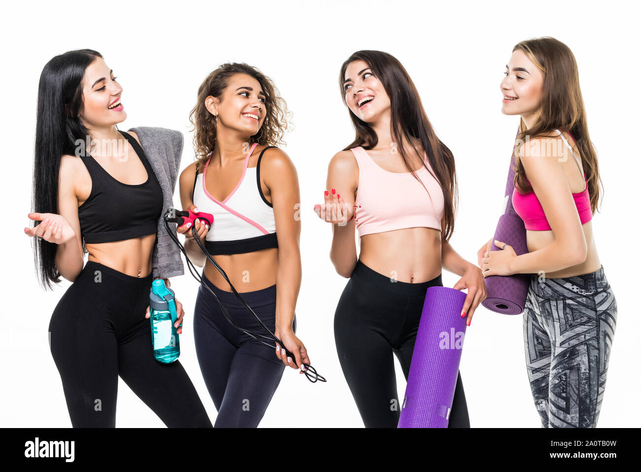 Four fitness girls in sportwear holding exercises equipment on white ...